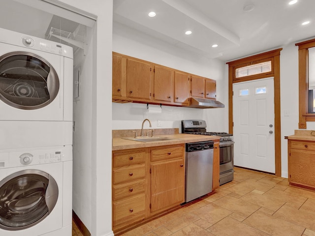 kitchen with stacked washer and dryer, stainless steel appliances, and sink