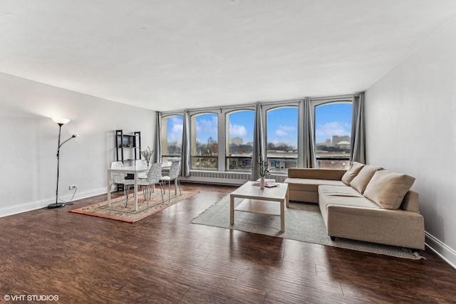 living area with baseboards, wood finished floors, and floor to ceiling windows