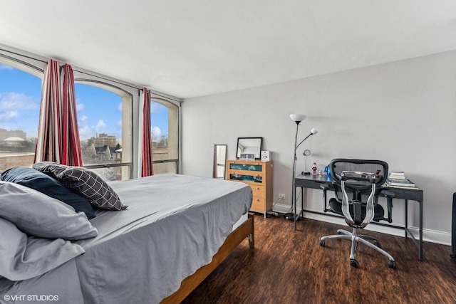 bedroom with dark wood-type flooring and baseboards