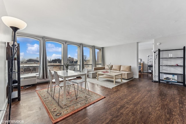 living room with baseboards, a wall of windows, and dark wood-style flooring