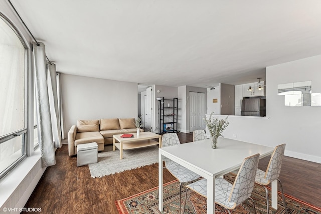 dining space featuring dark wood-style flooring and baseboards