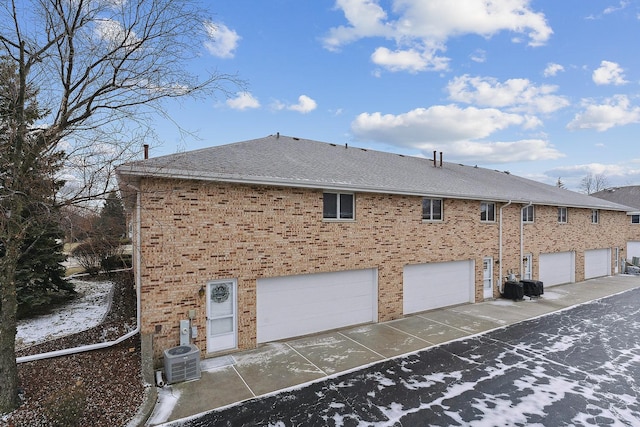 view of property exterior with a garage and central air condition unit