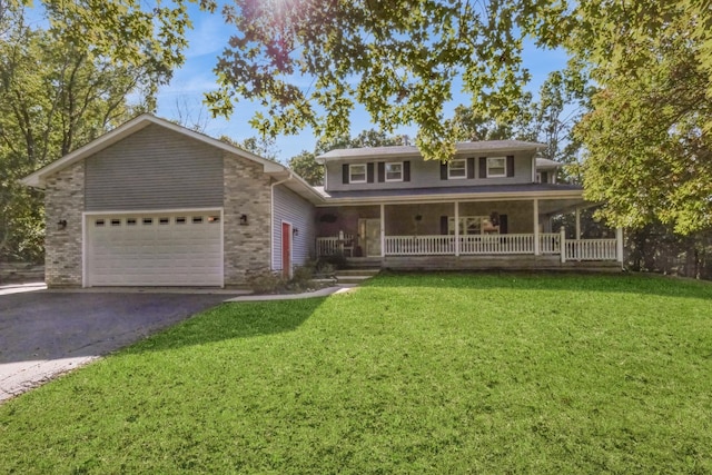 view of front of house with covered porch, a garage, and a front lawn