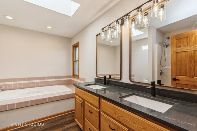 bathroom with vanity, wood-type flooring, independent shower and bath, and a skylight