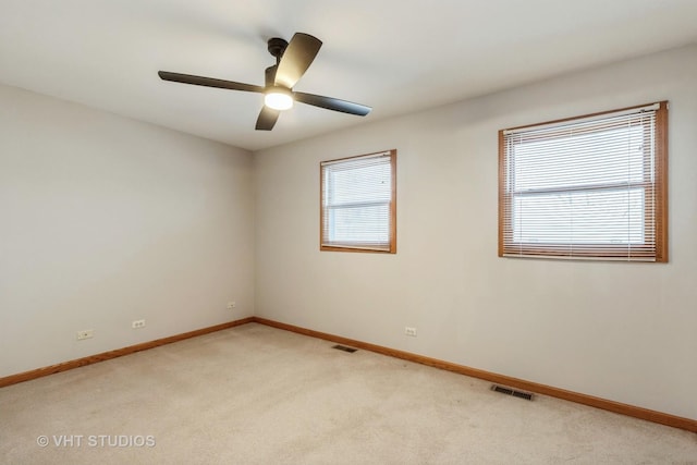 carpeted spare room with ceiling fan