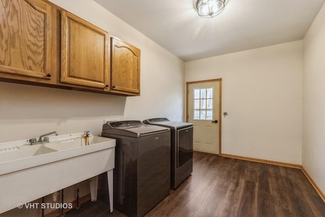 laundry area featuring washer and dryer, dark hardwood / wood-style flooring, cabinets, and sink