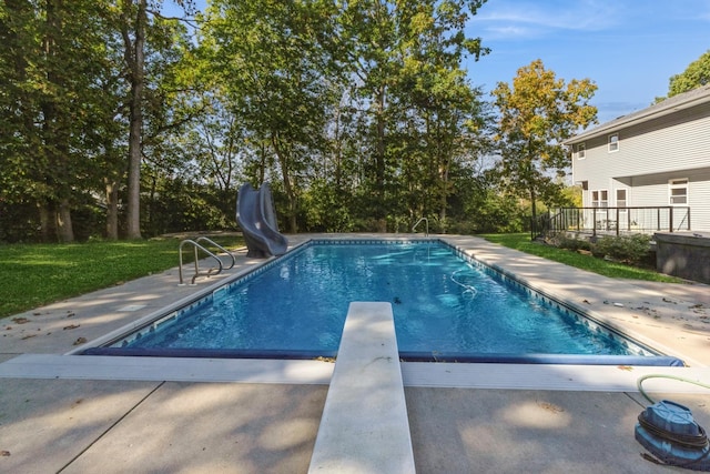 view of swimming pool featuring a diving board, a patio area, and a water slide