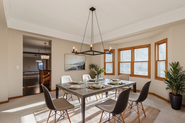 dining room featuring crown molding, light carpet, and a chandelier