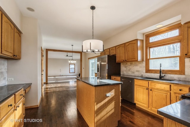 kitchen with sink, hanging light fixtures, black dishwasher, stainless steel fridge with ice dispenser, and a kitchen island