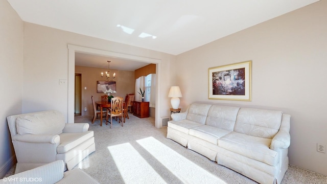 living room featuring light carpet and an inviting chandelier