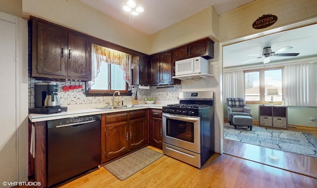 kitchen featuring black dishwasher, gas stove, plenty of natural light, and sink