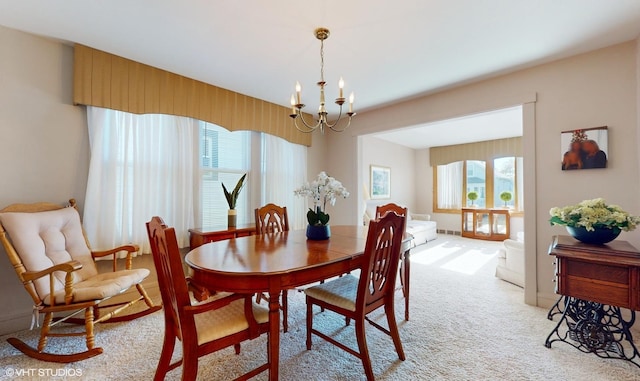 dining room featuring a chandelier and light colored carpet