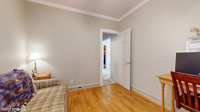 sitting room with ornamental molding and light hardwood / wood-style flooring