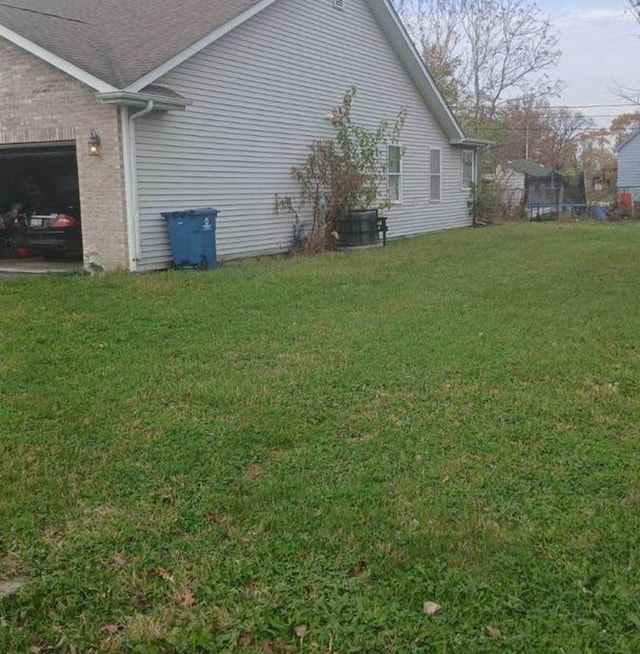 view of property exterior with a yard and a trampoline