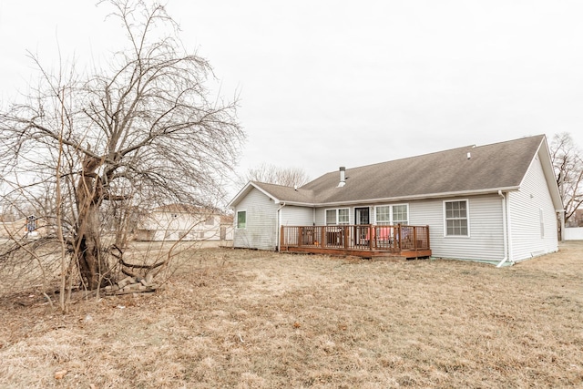 back of property with a wooden deck and a yard