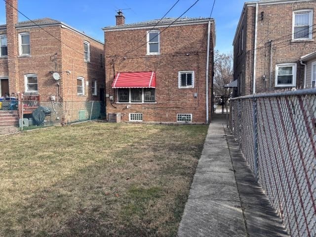 rear view of property featuring a yard