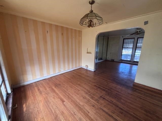 unfurnished dining area with dark hardwood / wood-style flooring, ornamental molding, and an inviting chandelier