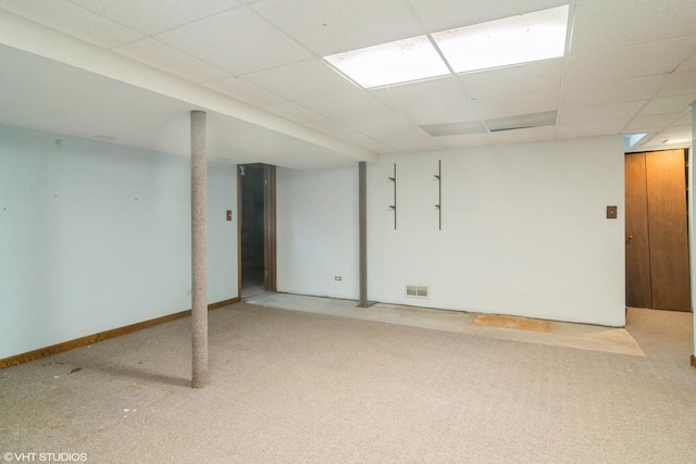 basement featuring a paneled ceiling and carpet floors