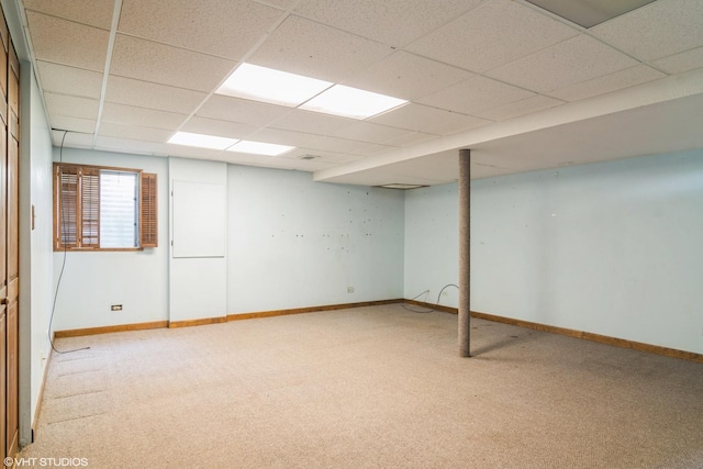 basement with carpet and a paneled ceiling