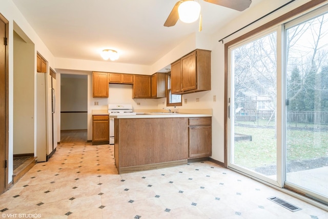 kitchen featuring white appliances, ceiling fan, and sink