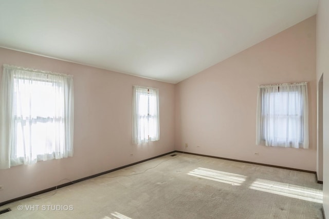 carpeted empty room with vaulted ceiling