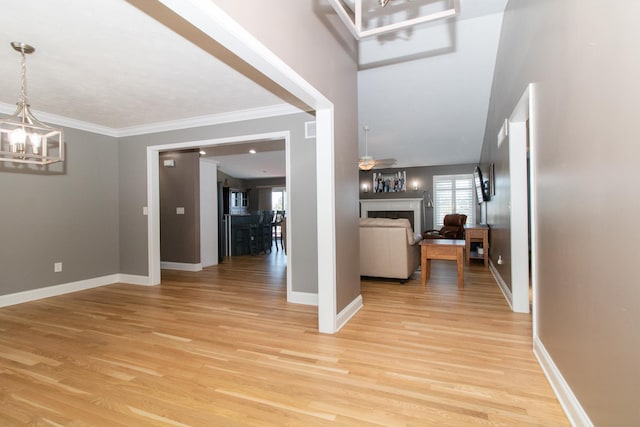 entrance foyer featuring crown molding, light hardwood / wood-style floors, and an inviting chandelier