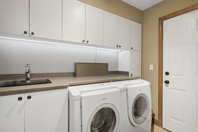 laundry area featuring cabinets, independent washer and dryer, and sink