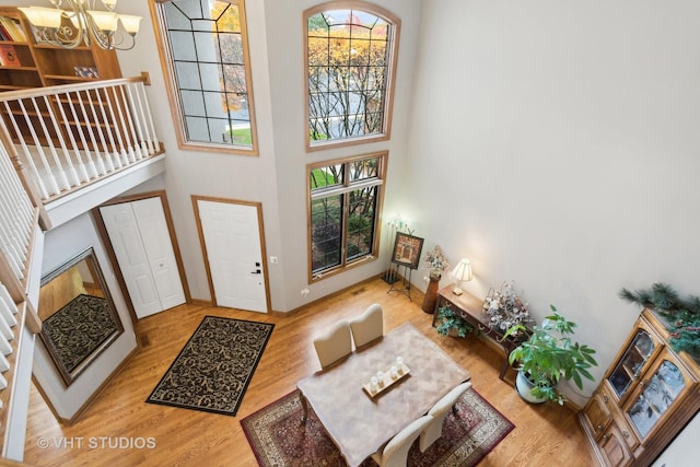 entrance foyer featuring a high ceiling, hardwood / wood-style flooring, and a notable chandelier