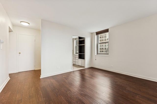 unfurnished bedroom featuring dark wood-style floors and baseboards