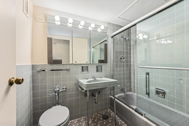 full bath featuring toilet, enclosed tub / shower combo, and tile walls