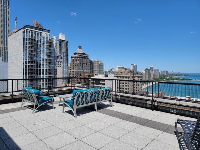 view of patio / terrace with a city view, a water view, an outdoor living space, and a balcony