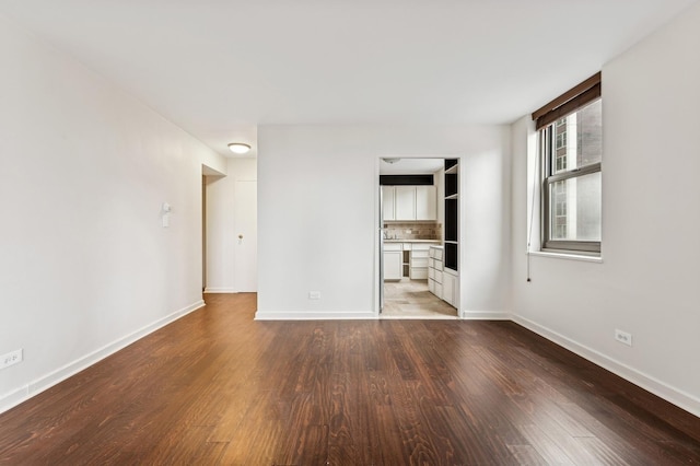 unfurnished bedroom with baseboards and wood finished floors