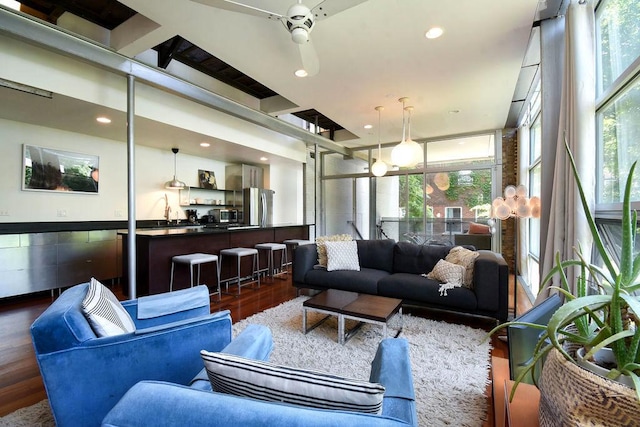 living room with dark hardwood / wood-style floors, a healthy amount of sunlight, and ceiling fan