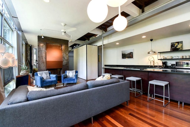 living room featuring ceiling fan and dark wood-type flooring