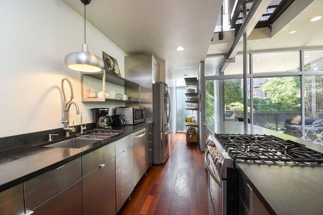 kitchen with hanging light fixtures, sink, dark hardwood / wood-style floors, appliances with stainless steel finishes, and dark brown cabinets