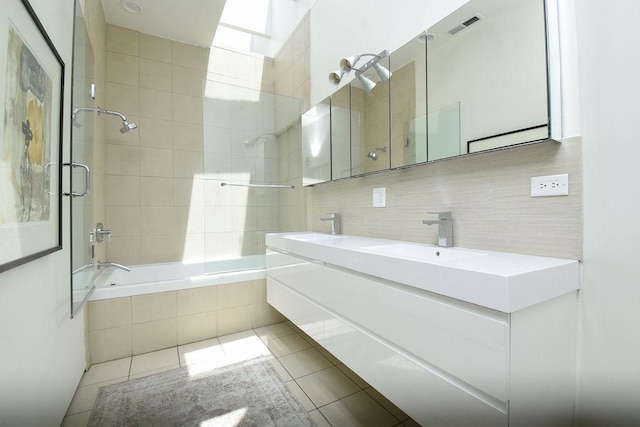 bathroom featuring tile patterned flooring, tiled shower / bath combo, and vanity