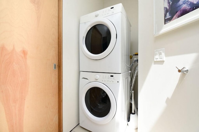 washroom featuring tile patterned floors and stacked washer / dryer