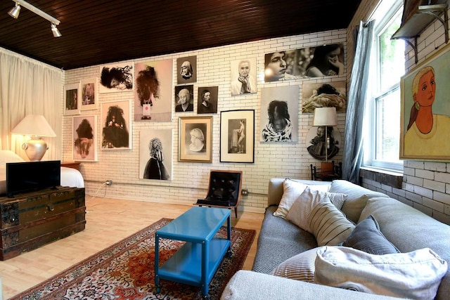 living room with hardwood / wood-style flooring, wood ceiling, and brick wall