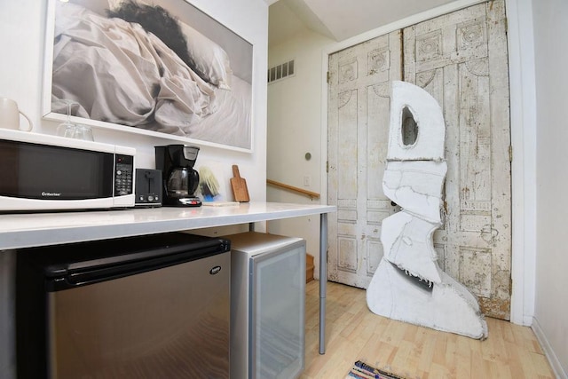 kitchen with fridge and light wood-type flooring