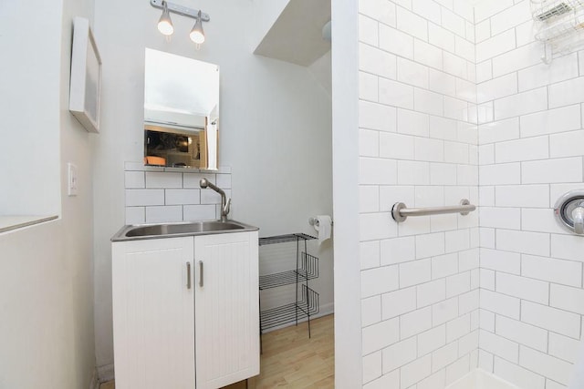 bathroom with hardwood / wood-style floors, backsplash, and sink