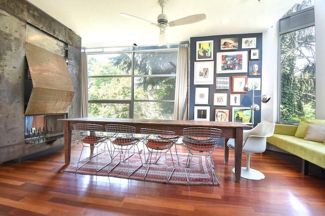 sitting room with expansive windows, dark hardwood / wood-style floors, and ceiling fan