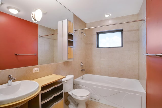 full bathroom with tile patterned floors, tiled shower / bath, sink, toilet, and tile walls