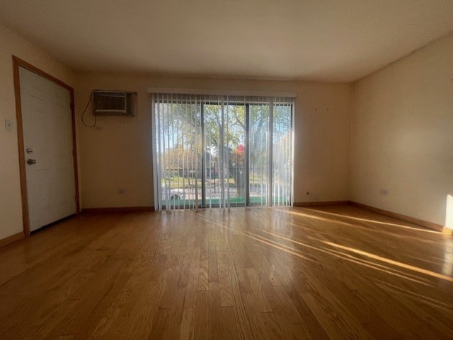 empty room featuring wood-type flooring and a wall mounted AC