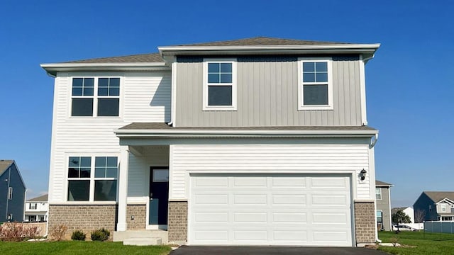 view of front property featuring a garage and a front lawn