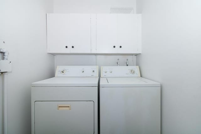 laundry room featuring cabinets and washer and clothes dryer