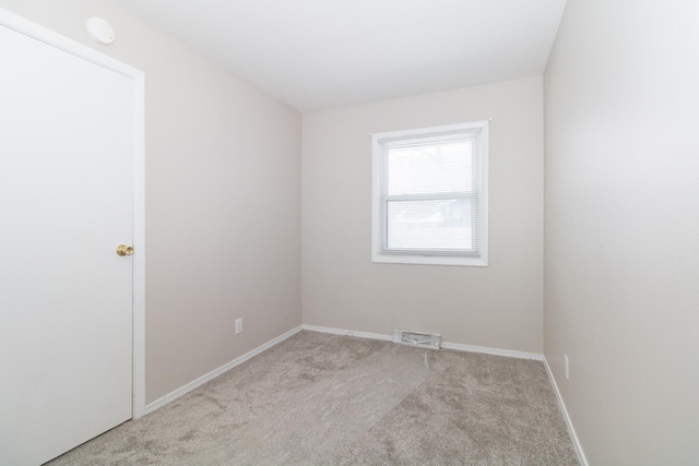 spare room featuring light colored carpet