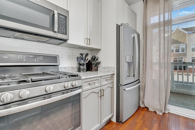 kitchen with stainless steel appliances, dark hardwood / wood-style floors, decorative backsplash, and white cabinets