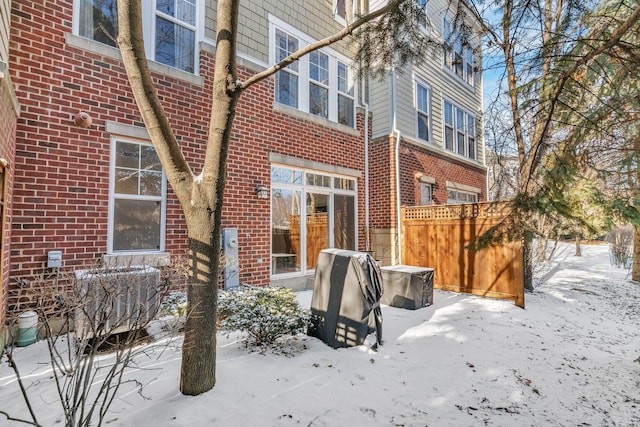 snow covered back of property with cooling unit