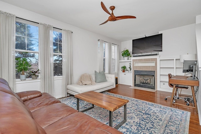 living room featuring hardwood / wood-style flooring, ceiling fan, a healthy amount of sunlight, and a fireplace