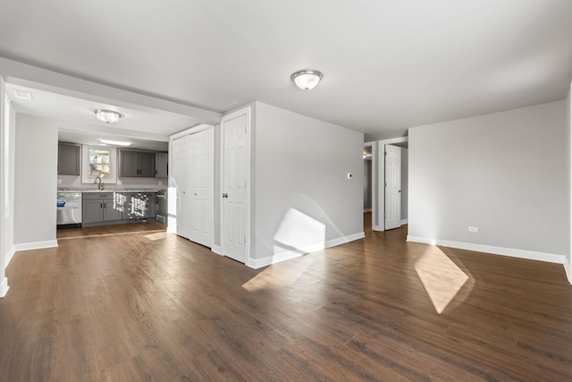 unfurnished living room featuring dark hardwood / wood-style floors and sink